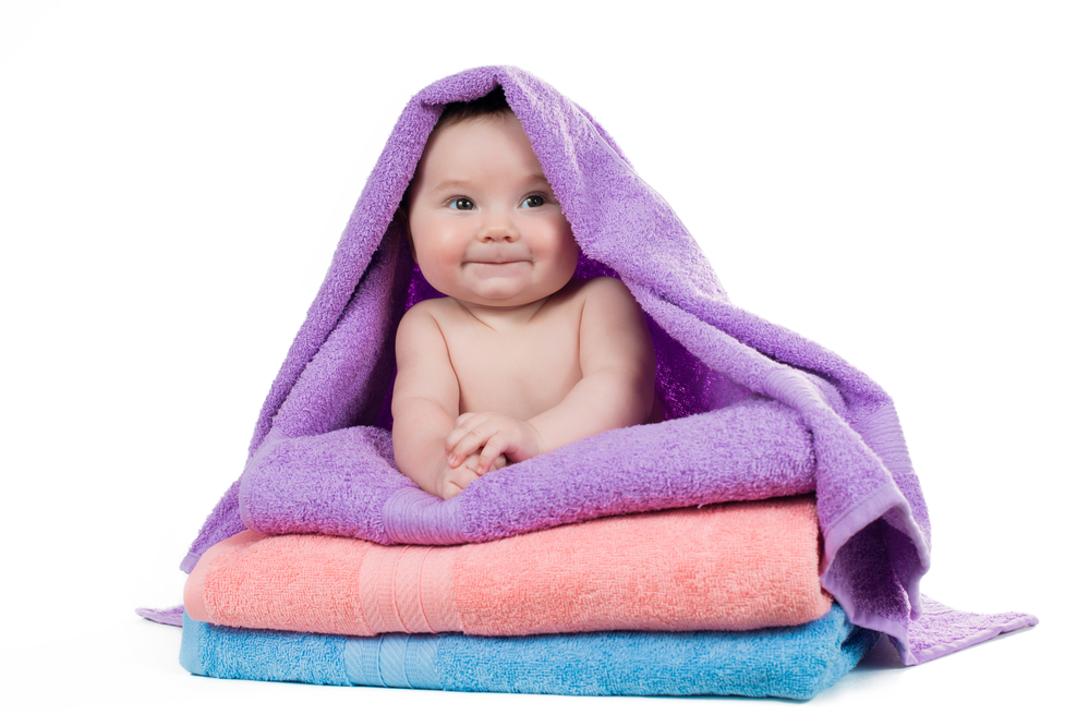 Newborn baby lying on a stack of towels